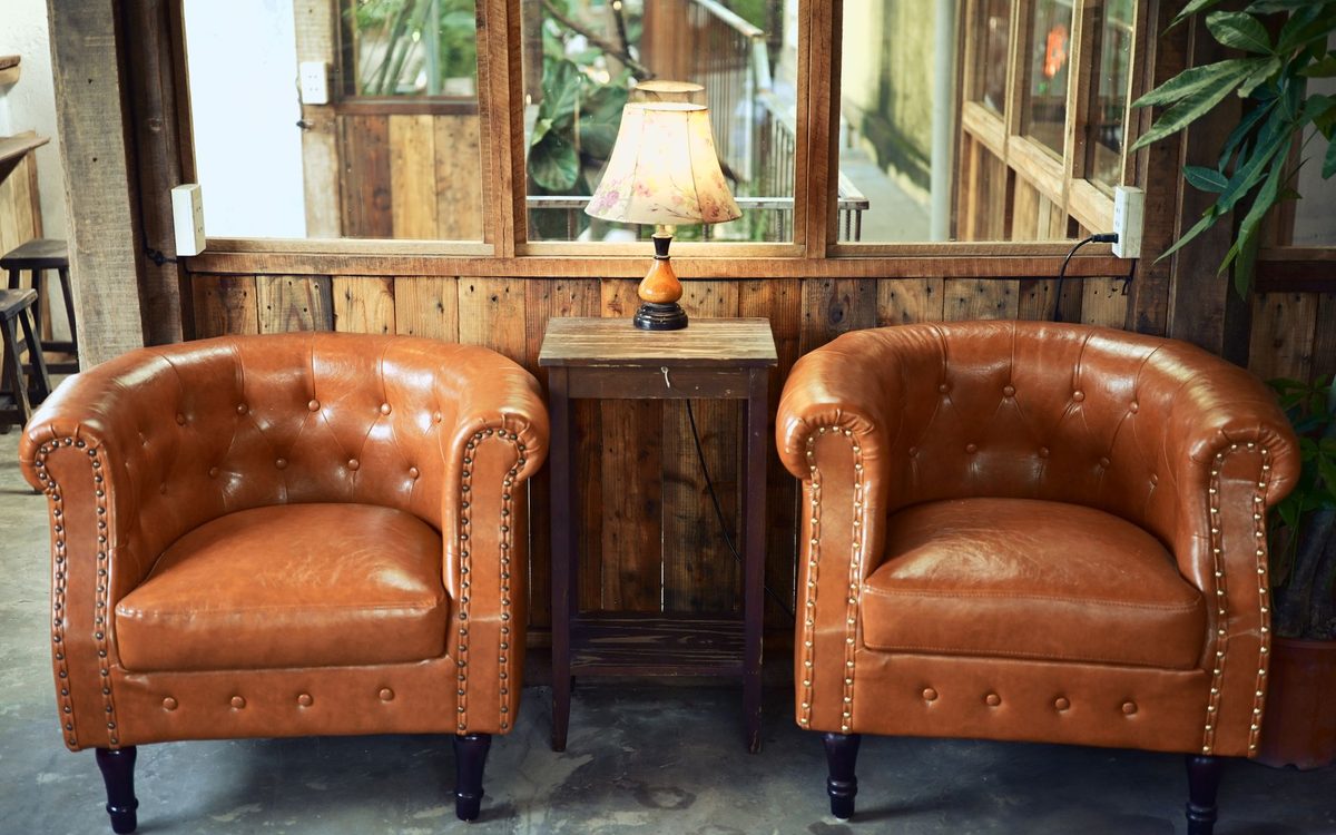 Leather armchairs and a wooden lamp in a cozy living room seating corner